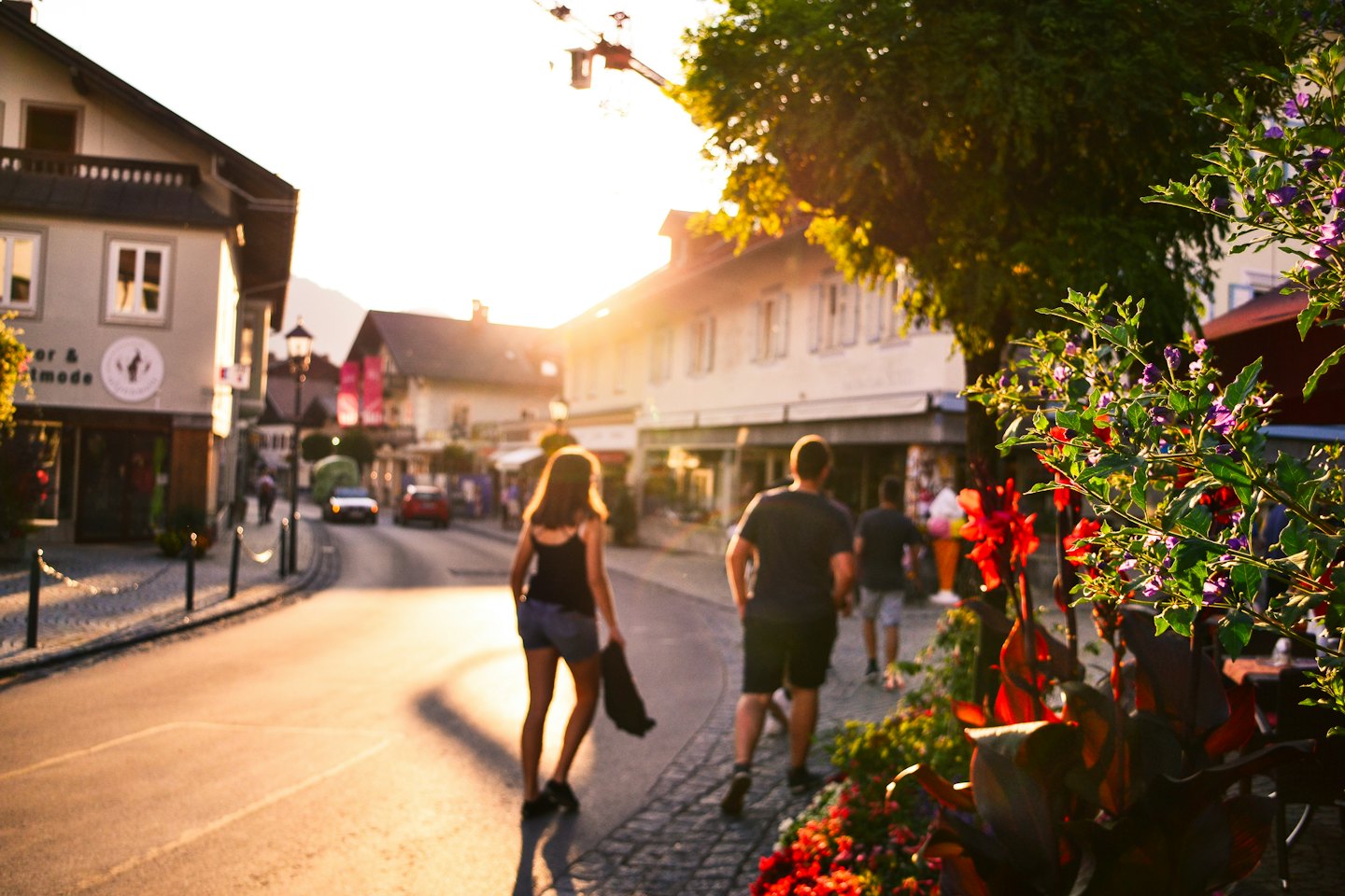 Couple walking on a cobblestone street at golden hour.